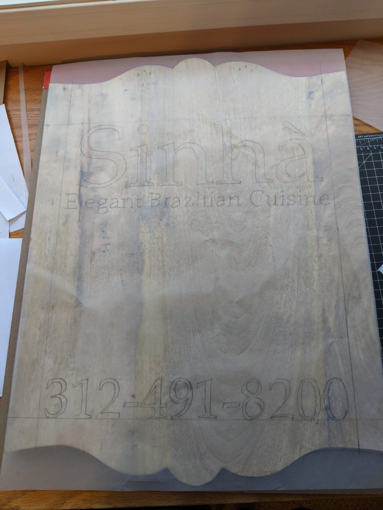 Tracing paper cut to fit wood sign.